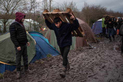 Camp de Grande-Synthe 11 janvier 2016, France, camp de réfugiés de Grande-Synthe. Les autorités ont autorisé ce lundi les bénévoles à faire rentrer dans le camp des matériaux. Les réfugiés récupèrent des palettes de bois pour circuler à l'abri de la boue.